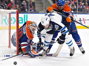 Winnipeg Jets' Joel Armia (40) is stopped by Edmonton Oilers' goalie Jonas Gustavsson (50) as Griffin Reinhart (8) defends during first period NHL pre-season action in Edmonton, Alta., on Thursday October 6, 2016.