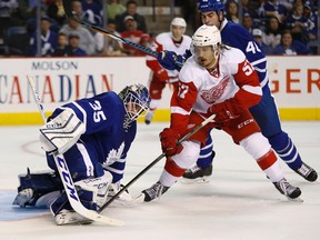 Detroit Red Wings' Mitch Callahan jams at the puck under Toronto Maple Leafs goalie Jhonas Enroth's pad during the second period at the First Ontario Centre in Hamilton on Friday. (Jack Boland/Toronto Sun)