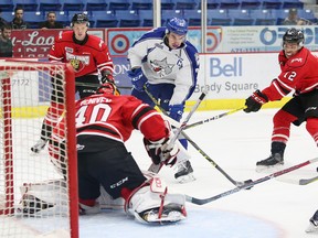 Kyle Capobianco, middle, of the Sudbury Wolves, fires a puck at goalie Michael McNiven, of the Owen Sound Attack, during OHL action at the Sudbury Community Arena in Sudbury, Ont. on Friday October 7, 2016. John Lappa/Sudbury Star/Postmedia Network