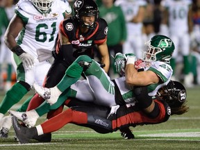Redblacks' Tanner Doll takes down Saskatchewan Roughriders receiver Rob Bagg at TD Place on Oct. 7. (The Canadian Press)