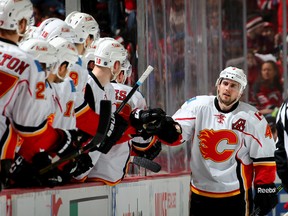 Kris Russell #4 of the Calgary Flames celebrates his goal with teammates on the bench in the second period against the New Jersey Devils on January 19,2016 at Prudential Center in Newark, New Jersey. (Photo by Elsa/Getty Images)