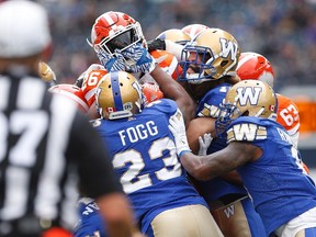 B.C. Lions' Anthony Allen (26) runs against Winnipeg Blue Bombers' Kevin Fogg (23) during the first half of CFL action in Winnipeg Saturday, October 8, 2016. (THE CANADIAN PRESS/John Woods)