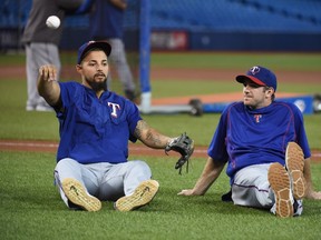 Texas Rangers' Rougned Odor and Jared Hoying sit on the field on workout day in advance of American League Division Series Game 3 in Toronto on Oct. 8, 2016. (THE CANADIAN PRESS/Jon Blacker)