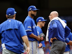 Toronto Blue Jays manager John Gibbons checks on relief pitcher Francisco Liriano after Liriano was hit on the back of the head by a single off the bat of Texas Rangers' Carlos Gomez in the eighth inning of Game 2 of an American League Division Series on Oct. 7, 2016, in Arlington, Texas. (AP Photo/LM Otero)