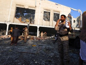 People inspect the aftermath of a Saudi-led coalition airstrike in Sanaa, Yemen, Saturday, Oct. 8, 2016. Yemeni security and medical officials say at least 140 people have been killed in a Saudi-led coalition airstrike that targeted a funeral hall in the capital, Sanaa. The officials say at least another 100 have been wounded in the Saturday strike. (AP Photo/Osamah Abdulrhman)