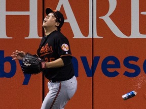 Baltimore Orioles' Hyun Soo Kim gets under a fly ball as a beer can sails past him during seventh inning American League wild-card game action against the Toronto Blue Jays in Toronto, Tuesday, Oct. 4, 2016. (THE CANADIAN PRESS/Mark Blinch)