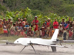 In this July 27, 2016, file frame from video provided by Vayu, Inc., residents from Ranomafana, Madagascar, watch before a drone containing medical samples takes off on a test flight from their remote village, which can only be reached on foot. Off Africa’s eastern coast in Madagascar, U.S. company Vayu completed drone flights to deliver blood and stool samples from rural villages, with support from the U.S. Agency for International Development. (Stony Brook University/Vayu Inc. via AP, File)