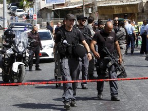 Israeli police secures the scene where a car driven by a Palestinian gunman was intercepted by the police and gunman shot dead in Jerusalem Sunday, Oct. 9, 2016. A Palestinian motorist launched a shooting spree near the Israeli police headquarters in Jerusalem Sunday, killing two and wounding several more before being shot dead, Israeli police and emergency services said. (AP Photo/Mahmoud Illean)