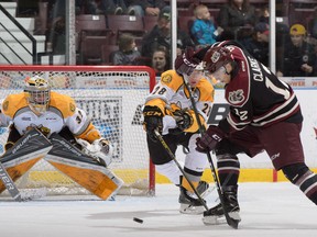Peterborough Petes forward C.J. Clarke and Sarnia Sting defenceman Kelton Hatcher both reach for the puck in front of Sting goalie Justin Fazio during the Ontario Hockey League game at Progressive Auto Sales Arena on Saturday, Oct. 8, 2016 in Sarnia, Ont. The Sting won 3-2 in a shootout. Metcalfe Photography