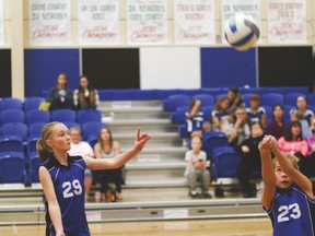 Junior high Hawks volleyball players Anna Lundgren (right) and Dayna Hilz keep the ball off the ground during their game against the Coaldale Christian Titans last Monday. The Hawks won the first two sets to win the game. The first set a win of 25-11, the second 25-12.