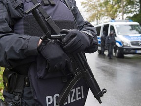 Police officers secure a road in the eastern city of in Chemnitz, Germany, Saturday, Oct. 8, 2016. German investigators found several hundred grams of explosives in an apartment they raided Saturday in the eastern city of Chemnitz as they sought a Syrian man suspected of planning a bombing attack. The suspect remained on the run but three contacts were detained and being questioned, police said. (AP Photo/Jens Meyer)