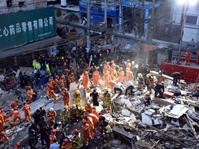Rescuers search for survivors at an accident site after four buildings caved in during the early hours in Wenzhou, eastern China's Zhejiang province on October 10, 2016. Four people were killed when a group of houses collapsed in China on October 10, a local government said. (AFP PHOTO / STR / China OUTSTR/AFP/Getty Images)