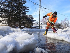 Loyalist Township employee Shawn Seymour shovels ice from Gore Street in Odessa on Jan. 23, 2014, as the Millhaven Creek flooded properties in the town. Loyalist Township applied for federal funding to find a solution to re-occurring flooding in the town. (Elliot Ferguson/The Whig-Standard)