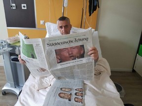 Trent Hills Mayor Hector Macmillan checks out newspaper coverage of Sunday night's U.S. presidential debate from his hospital bed in Stralsund, Germany on Oct. 10, 2016. (Supplied)
