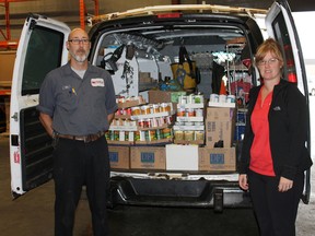 Steve Murphy, service manager at  Northern Air 669 HEAT, and Kathy Eadie, office manager, collect donations for the food bank. (Photo supplied)