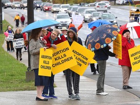 Anti-abortion protesters walk Paris Street in on Oct. 2. A large number of the protesters walked the sidewalk near Health Sciences North. (Gino Donato/Sudbury Star)