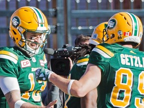 Edmonton Eskimos quarterback Mike Reilly, left, celebrates with teammate Chris Getzlaf after running in for a touchdwon during second-half action against the Montreal Alouettes in Montreal, Monday. (The Canadian Press)