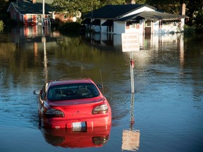 A car is submerged in floodwaters caused by rain from Hurricane Matthew in Lumberton, N.C., Monday, Oct. 10, 2016. (AP Photo/Mike Spencer)