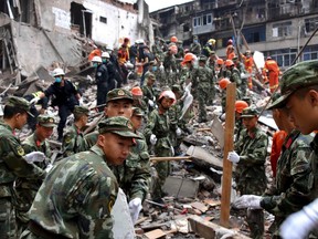 Rescuers clear the debris to search for victims on the site of collapsed residential buildings in Wenzhou city in east China's Zhejiang province, Monday, Oct. 10, 2016. More than dozen people were believed to be buried after four residential houses collapsed on Monday early morning. (AP Photo)