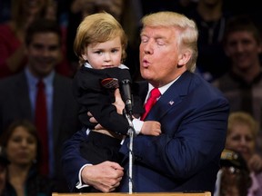 Republican presidential nominee Donald Trump kisses a child dressed as him during a rally at Mohegan Sun Arena in Wilkes-Barre, Pennsylvania on October 10, 2016. / AFP PHOTO / DOMINICK REUTERDOMINICK REUTER/AFP/Getty Images