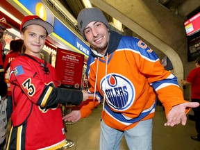 Elini Yannitsos, 13, sports a Johnny Gaudreau jersey and points at Larry Parker's Connor McDavid's Oilers jersey during the Calgary Flames Red Rally at the Scotiabank Saddledome in Calgary, Alta on Saturday October 8, 2016. Fans had a chance to meet players, tour the Dome, and listen to the coach narrate a one hour practice session. The Flames open the regular season against the Oilers in Edmonton on Thursday and then at home this Friday. Jim Wells//Postmedia