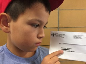 Joseph Francis Kennedy, a nine-year-old Grade 5 student at Ecole Cathedrale, shows the letter he recently received from the Ministry of the General, Sheriff's Office – Jury Administration. (Patrick Kennedy/The Whig-Standard)