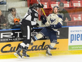 Brock Perry of the Blainville-Boisbriand Armada checks Julien Bahl #18 of the Sherbrooke Phoenix during the QMJHL game at the Centre d'Excellence Sports Rousseau on October 7, 2016 in Blainville-Boisbriand, Quebec, Canada. (Photo by Minas Panagiotakis/Getty Images)