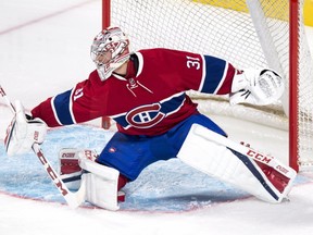 Montreal Canadiens goalie Carey Price deflects a shot as they face the Toronto Maple Leafs during first period of NHL pre-season hockey action Thursday, October 6, 2016 in Montreal. Price will miss the Canadiens NHL season opener with a flu, the team announced Wednesday. (THE CANADIAN PRESS/Paul Chiasson)