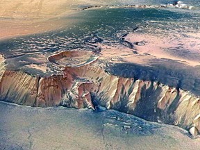 In this handout image supplied by the European Space Agency (ESA) on July 16, 2008, The Echus Chasma, one of the largest water source regions on Mars, is pictured from ESA's Mars Express. The data was acquired on September 25, 2005. An impressive cliff, up to 4000 m high, is located in the eastern part of Echus Chasma. Gigantic water falls may once have plunged over these cliffs on to the valley floor. The remarkably smooth valley floor was later flooded by basaltic lava. (Photo by ESA via Getty Images)