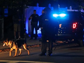 Police search for a suspect after a shooting in the East Boston neighborhood of Boston, Wednesday, Oct. 12, 2016. Police say two officers were shot late Wednesday night. Their conditions were not immediately available. It's unclear what led to the shooting. (AP Photo/Charles Krupa)