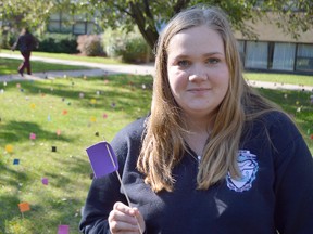 Madison Herreweyers stands in the courtyard at Ursuline College in Chatham Wednesday, where she and nine other students with the club Lancers for Life arranged one thousand multi-coloured flags. It was part of their pro-life display, each flag representing 100 abortions in Canada annually.