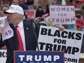 Republican presidential nominee Donald Trump kisses a "Women for Trump" placard during a rally at the Lakeland Linder Regional Airport in Lakeland, Fla. on Oct. 12, 2016. (AFP PHOTO)