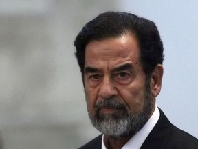 Former Iraqi president Saddam Hussein reacts to the verdict during his trial under tight security in Baghdad's heavily fortified Green Zone November 5, 2006. (Postmedia Network Files)