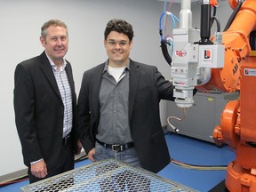 Roger Bowes, left, and Paul Webster stand next to an industrial robot in a lab at the new office of Laser Depth Dynamics in Kingston on Thursday. The company makes equipment to ensure the quality of laser welding. (Michael Lea/The Whig-Standard)
