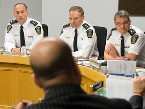Deputy chiefs Daryl Longworth, left, Steve Williams and Chief John Pare listen to fellow London police board member Michael Deeb, in foreground, at a board meeting Wednesday. (CRAIG GLOVER, The London Free Press)