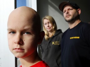 Luke Hendry/The Intelligencer
Aidan Reil, 10, who has a rare form of brain cancer, stands with his parents, Sarah Grover and Wayne Reil, at The Intelligencer offices Thursday in Belleville. His parents want the Canadian government and other organizations to increase funding for children's cancer.