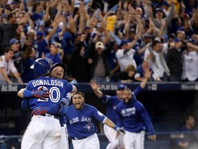 Josh Donaldson of the Toronto Blue Jays celebrates with teammate Troy Tulowitzki after the Toronto Blue Jays defeated the Texas Rangers 7-6 in ten innings for game three of the American League Division Series at Rogers Centre on October 9, 2016 in Toronto, Canada. (Tom Szczerbowski/Getty Images)