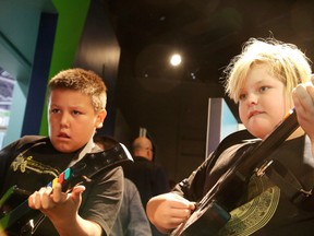 Jayden Copegog and Justice Rancourt, Grade 4 and 5 students at Lansdowne Public School, play Guitar Hero at a new travelling exhibition, Game Changers, that was officially launched at Science North in Sudbury, Ont. on Thursday October 13, 2016. The highly interactive exhibition, developed and produced by the Canada Science and Technology Museum, explores the relationship between a designer’s aspirations, a player’s expectations, and the ever-expanding limits of technology.Gino Donato/Sudbury Star/Postmedia Network