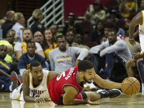 Toronto Raptors' Cory Joseph reaches for the ball in front of Cleveland Cavaliers' Jordan McRae as Kyrie Irving watches during the first half of an NBA preseason basketball game. (AP Photo/Phil Long)