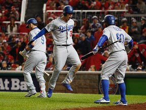 Los Angeles Dodgers Joc Pederson (31) celebrates his solo home run with teammates Yasmani Grandal (9) and Andrew Toles (60) during the seventh inning against the Washington Nationals in a baseball National League Division Series, at Nationals Park, Thursday, Oct. 13, 2016, in Washington. (AP Photo/Pablo Martinez Monsivais)