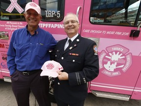 Toronto Firefighter Service and their union the TPFFA (Toronto Professional Firefighters Association) are showcasing "Louise" the pink training pumper off during the entire month of October to coincide with Breast Cancer Awareness Month. They are selling pink ball caps to raise money at events with the pumper to benefit the Louise Temerty Breast Cancer Centre at Sunnybrook hospital (Pictured L-R) TPFFA Gerlando Peritore Executive officer and Vice-President Damien Walsh with Louise on Thursday October 13, 2016. Jack Boland/Toronto Sun/Postmedia Network