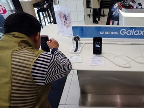 A visitor tries the Samsung Electronics' S7 edge smartphone at a shop of South Korean mobile carrier in Seoul, South Korea, Thursday, Oct. 13, 2016. (AP Photo/Lee Jin-man)