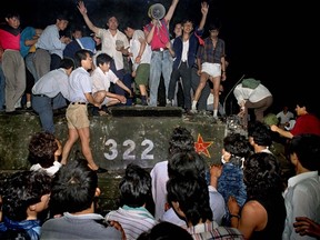 In this early June 4, 1989 file photo, civilians with rocks stand on a government armored vehicle near Chang'an Boulevard in Beijing as violence escalated between pro-democracy protesters and Chinese troops, leaving hundreds dead overnight. C prisoners in China. (AP Photo/Jeff Widener, File)