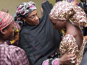In this photo released by the Nigeria State House, an unidentified government official, center, welcomes some of the freed Chibok school girls at the state House in Abuja, Nigeria, Thursday, Oct. 13, 2016. (Sunday Aghaeze/Nigeria State House via AP)