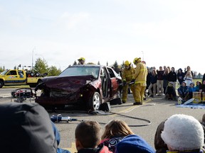 Members of SGFS use the Jaws of Life to remove the back door of a vehicle during a demonstration at Living Waters Christian Academy on Oct. 6. - Photo by Marcia Love