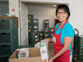Food bank volunteer Conchita Hidalgo, above, fills a box with supplies. Donations are always welcome at the Parkland Food Bank.  - File photo