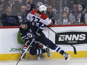 Blake Wheeler of the Winnipeg Jets hits Justin Faulk of the Carolina Hurricanes during Thursday night's game. (Photo by Jason Halstead /Getty Images)