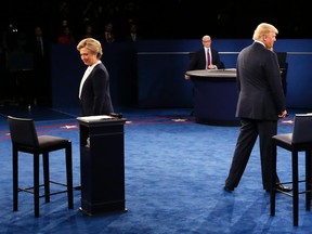 TOPSHOT - Democratic nominee Hillary Clinton (L) and Republican nominee Donald Trump arrive on stage during the second presidential debate at Washington University in St. Louis, Missouri on Oct. 9, 2016. (JIM BOURGJIM BOURG/AFP/Getty Images/Pool)