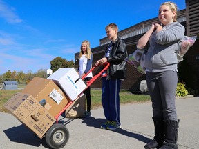 Tim Miller/The Intelligencer
Foxboro Public School students Sarah Vanmanen, Evan Moore and Jennifer Candler get ready to load up just a portion of the used footwear the school collected for the Lung Association's Mega Shoe Drive on Friday in Foxboro. The trio, along with student Teslyn St. Aubin-Bellerive (not pictured), were part of the student committee responsible for organizing the collection.