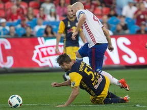 Toronto FC’s Michael Bradley dribbles past Red Bulls defender Damien Perrinelle during their game last month. (THE CANADIAN PRESS)